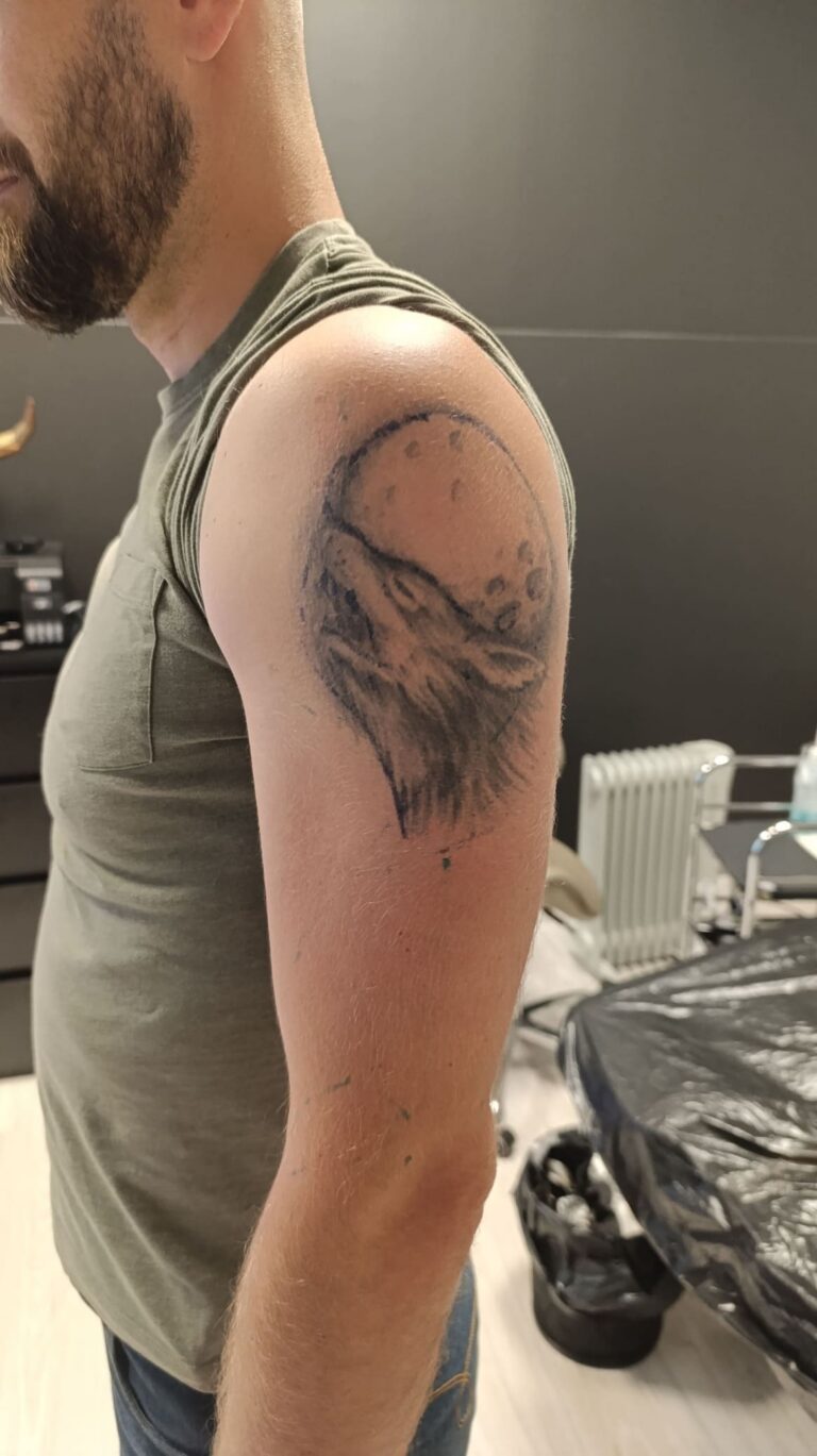 Realistic warrior cover up tattoo sleeve transforming an old wolf and moon tattoo with detailed black and grey forest composition.